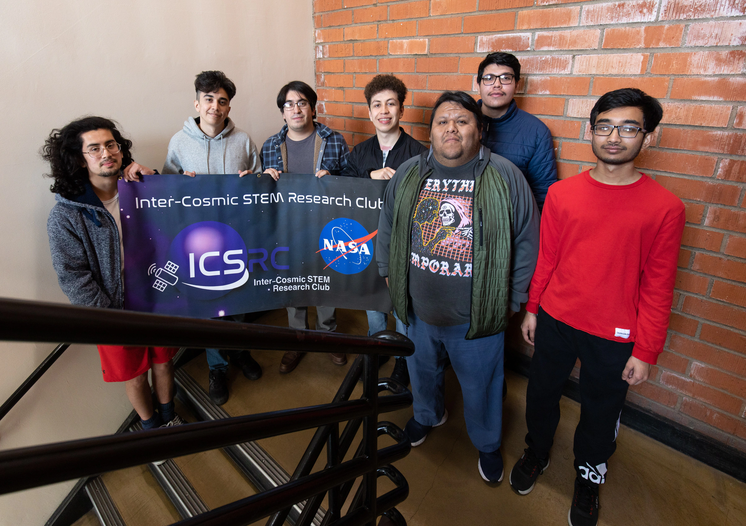 NASA MINDS team holding the Inter-Cosmic STEM Research Club banner